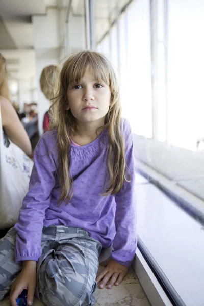 Havaalanında pencere üzerinde oturan kız — Stok fotoğraf