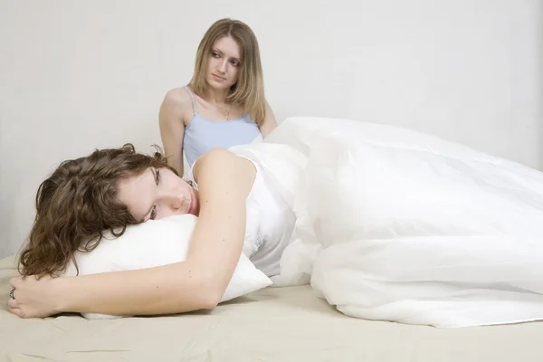 Atraente mulher loira pensativa com um travesseiro na cama. Ela... — Fotografia de Stock