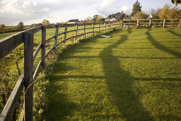 Голубое облачное небо и деревянный забор
