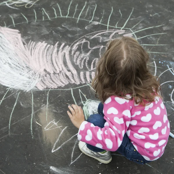 Little girl drawing images by chalk — Stock Photo, Image