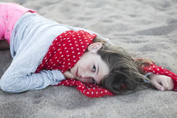 Menina jaz na areia — Fotografia de Stock