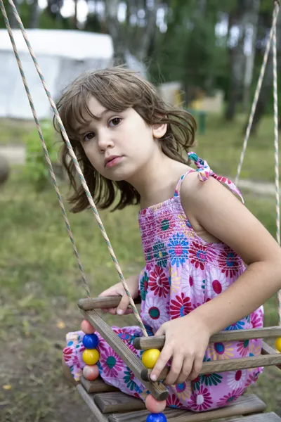 Litle flicka sitter på svingen — Stockfoto