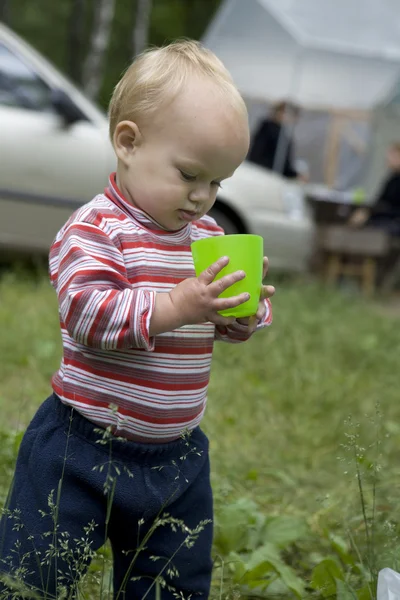 Schattige babymeisje spelen met plastic dop in het park — Stockfoto