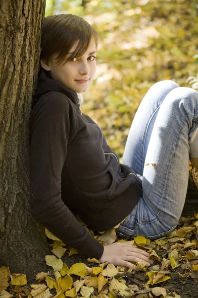 Ung vacker flicka bland gula hösten lämnar — Stockfoto
