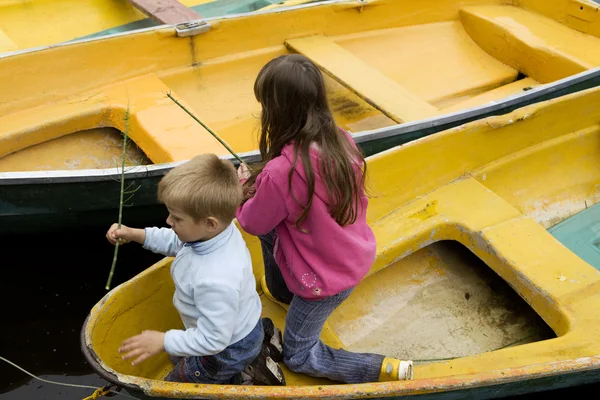 Amizade. Crianças brincando em barco amarelo. Hora de verão — Fotografia de Stock