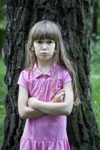 Flickan står nära stora trädet — Stockfoto