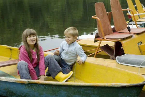 Amizade. Crianças brincando em barco amarelo. Hora de verão — Fotografia de Stock