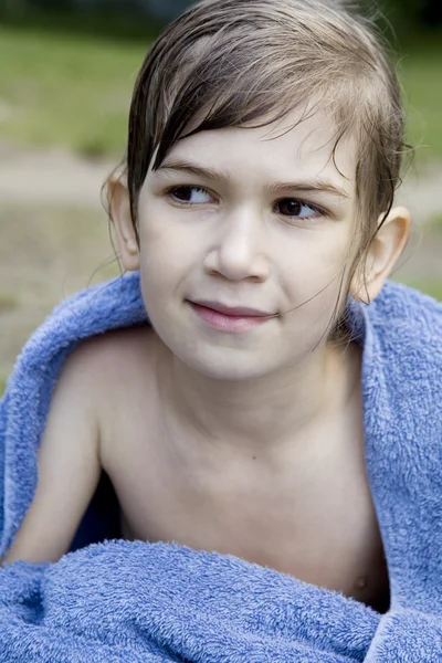 Klein schattig meisje, zittend op de oever van rivier — Stockfoto