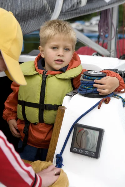 Kleiner süßer Junge in Schwimmweste auf Jacht. — Stockfoto