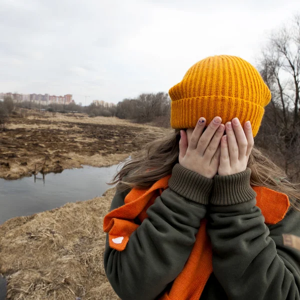 Trist teenager i orange strikket hat - Stock-foto