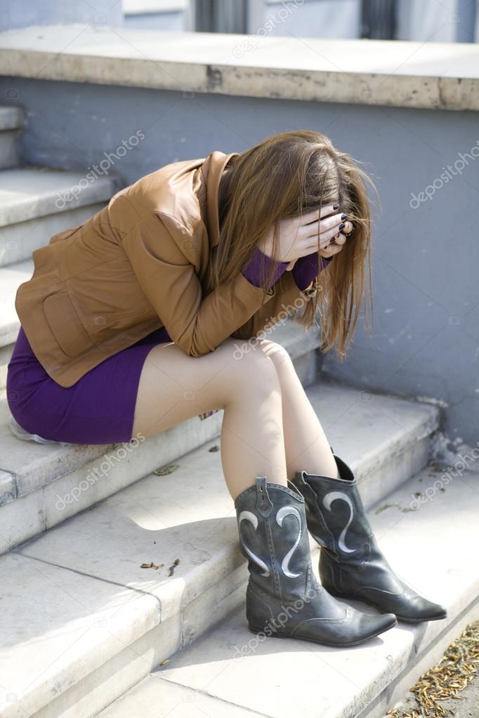 Depressed teen girl sitting on stairs