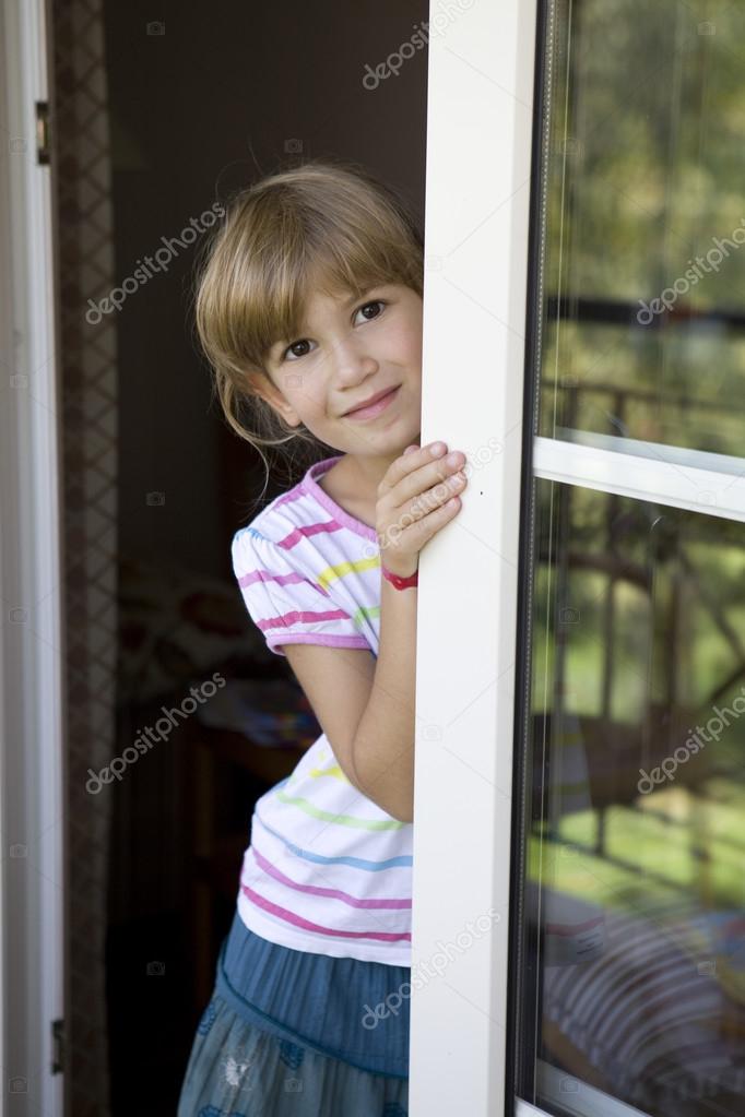 Girl looking out balcony door