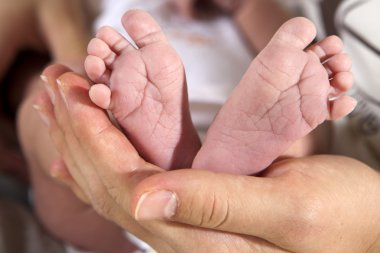 Ona bebeğin bacakları tutan anne