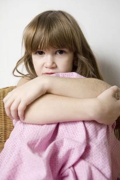 Sad little cute girl sitting on chair — Stock Photo, Image