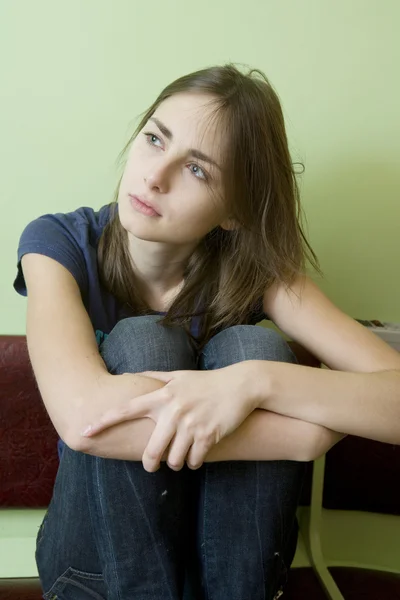 Menina perturbada sentado na parede . — Fotografia de Stock