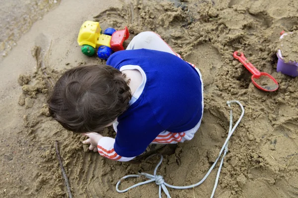 Menino brincando na areia — Fotografia de Stock