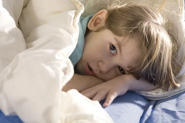 Meisje slaapt in het bed — Stockfoto