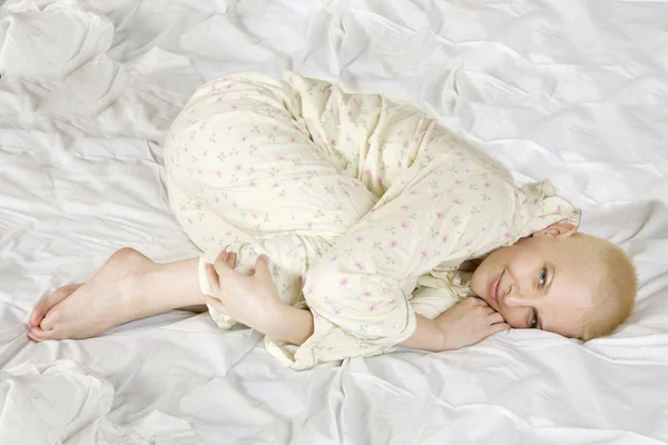 Thoughtful blond bald woman lying on the bed — Stock Photo, Image