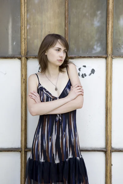 Sad young woman standing near window — Stock Photo, Image