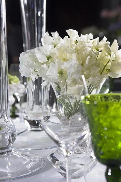 Bukett med vita blommor i vas av glas — Stockfoto