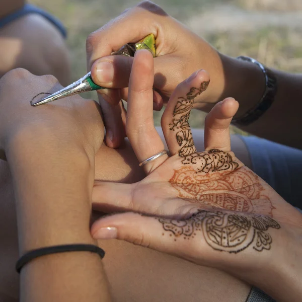 Eine Frau lässt sich vorübergehend Henna-Tätowierungen auf die Brust tätowieren — Stockfoto