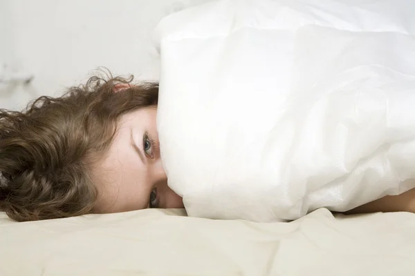 Brunette curl vrouw liggend op het bed — Stockfoto