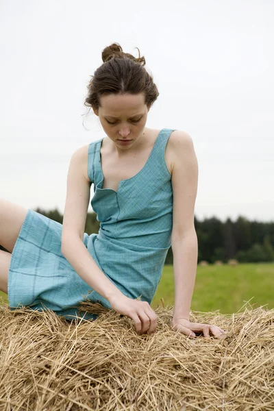 Young pretty girl is sitting hayrick — Stock Photo, Image