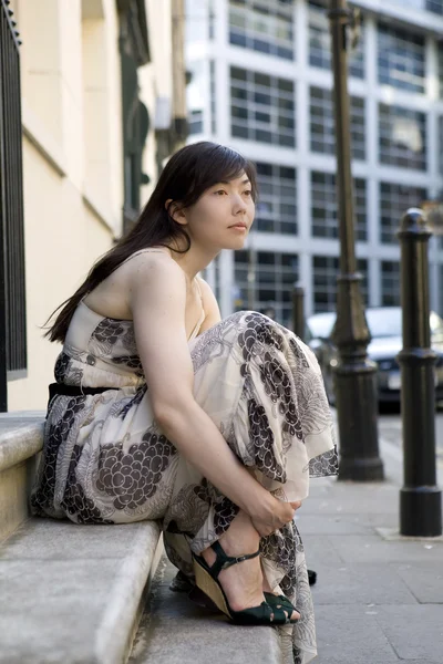 Joven mujer pensativa sentada en escaleras de piedra . — Foto de Stock