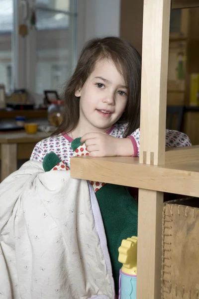 Ung söt leende flicka med långt hår står på bokhyllan — Stockfoto