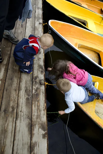 Amizade. Crianças brincando em barco amarelo. Hora de verão — Fotografia de Stock