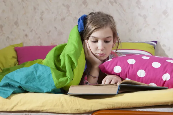 Mädchen liest im Bett — Stockfoto