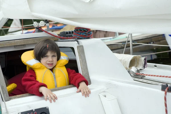 Piccola ragazza carina in giubbotto di salvataggio su yacht — Foto Stock