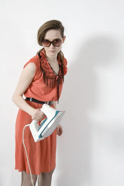 Aggressive woman with iron standing at white wall — Stock Photo, Image