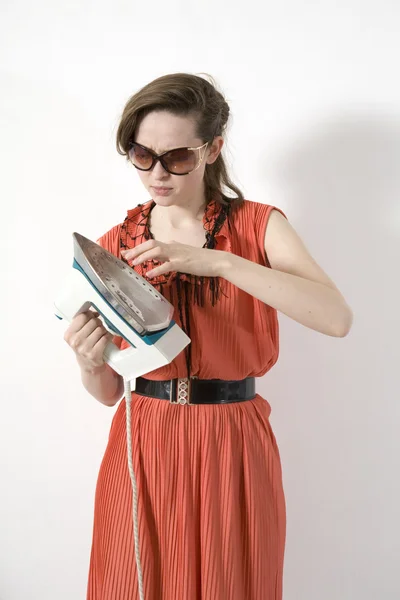 A woman try to understand how hot iron - on white background — Stock Photo, Image