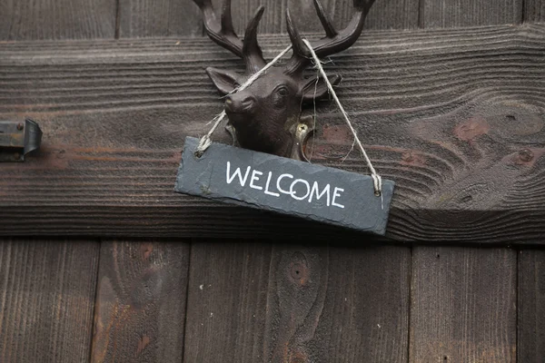 Cabeça de veado e sinal de boas-vindas — Fotografia de Stock