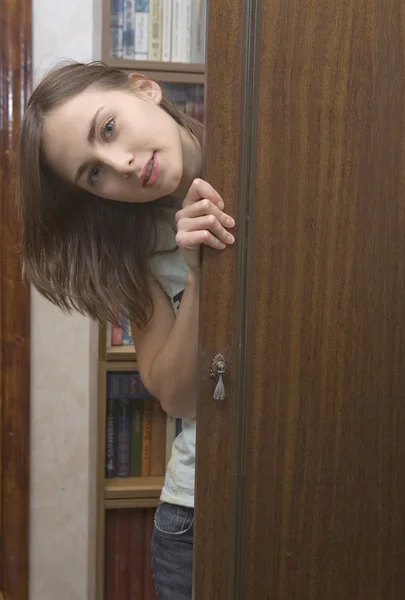La jeune femme regardant par derrière la porte — Photo