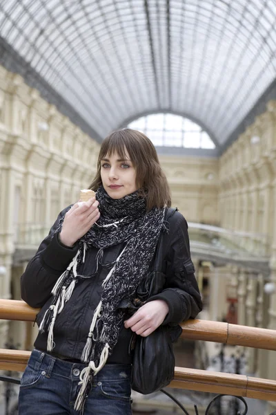 Joven atractiva mujer comer helado de pie en barandilla en —  Fotos de Stock