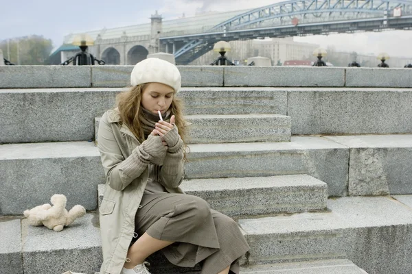 Молодая девушка сидит на jaggies и курить — стоковое фото