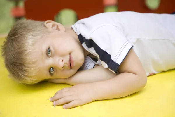 Pequeño chico lindo mintiendo — Foto de Stock