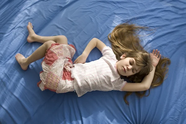 Little dreaming girl lying on the bed — Stock Photo, Image