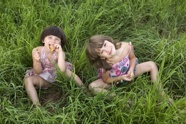 Två tjejer sitter i gräset — Stockfoto