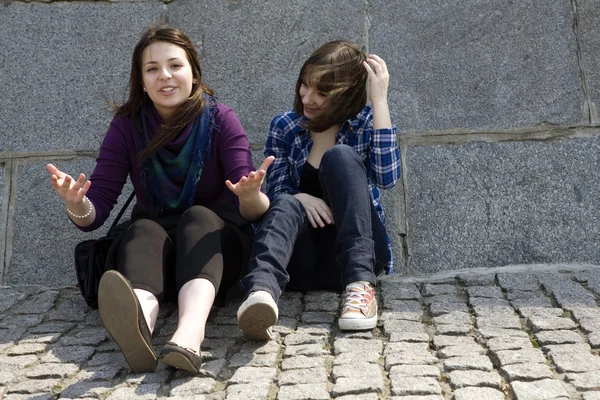 Urban teen girls sitting at stone wall — Stock Photo, Image