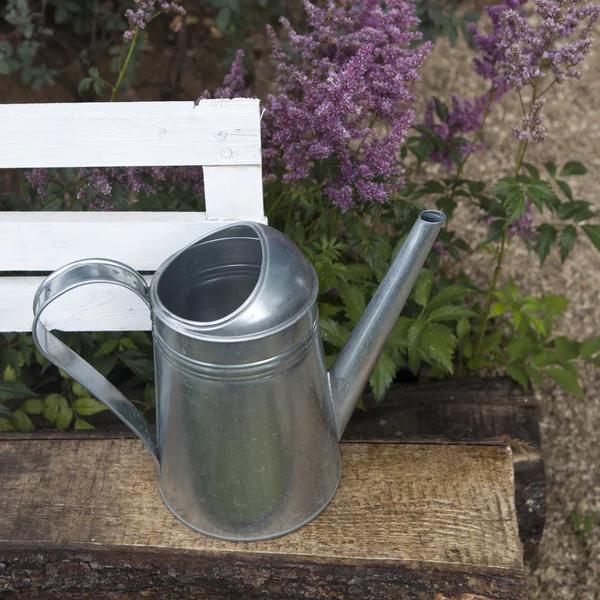 New metal watering can hanging on hense. — Stock Photo, Image