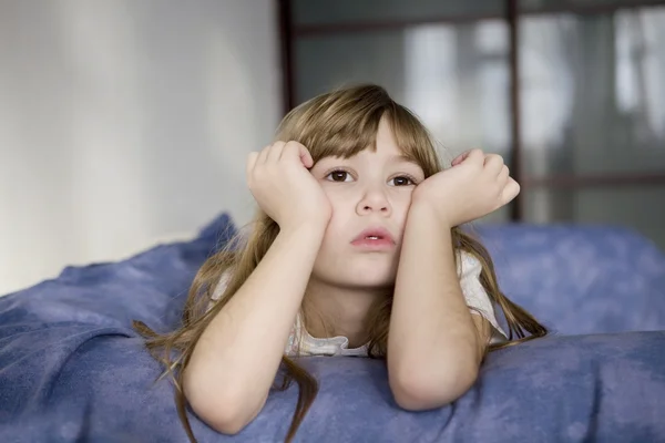 Pouco bonito menina sete anos de idade deitado na cama — Fotografia de Stock