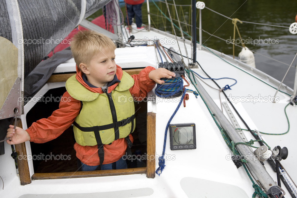 Little cute boy  in life jacket on yacht.