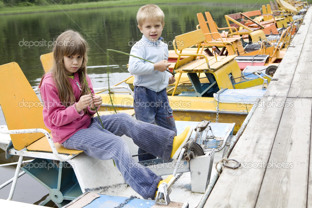 Friendship. Children playing in yellow boat. Summer time