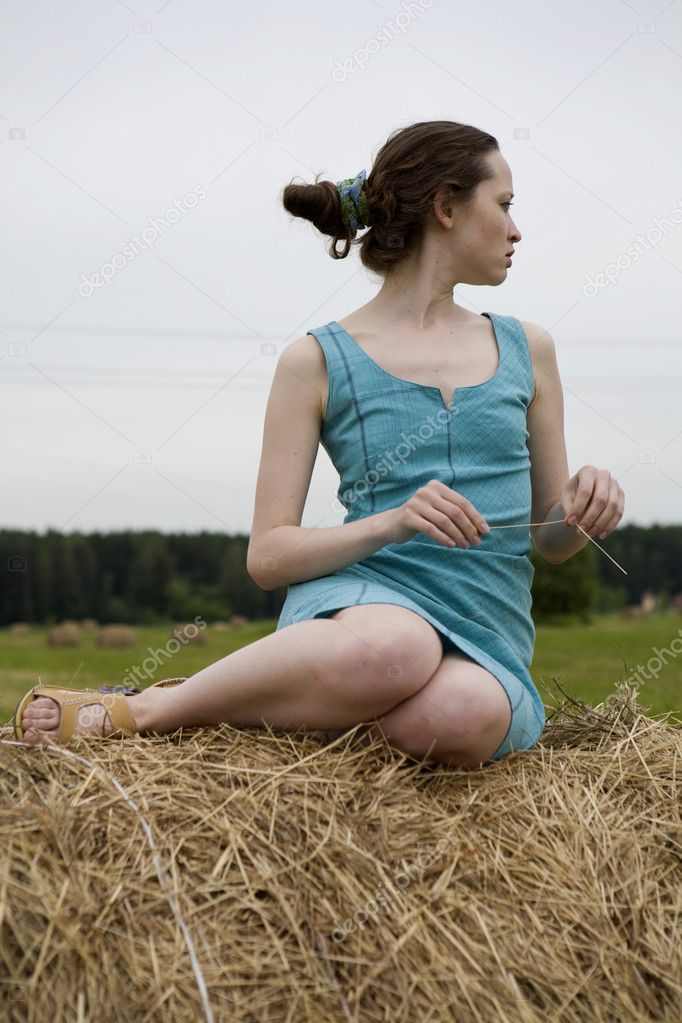 Young girl sitting on the hayrick