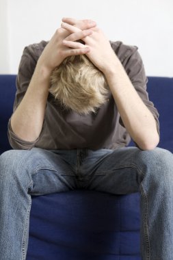 Koltukta oturan üzgün sarışın adam