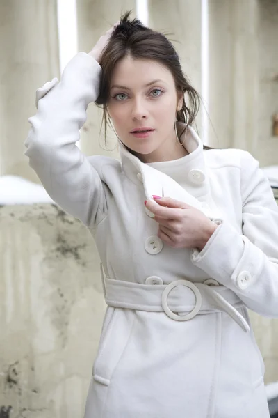 Young attractive woman wearing white overcoat — Stock Photo, Image
