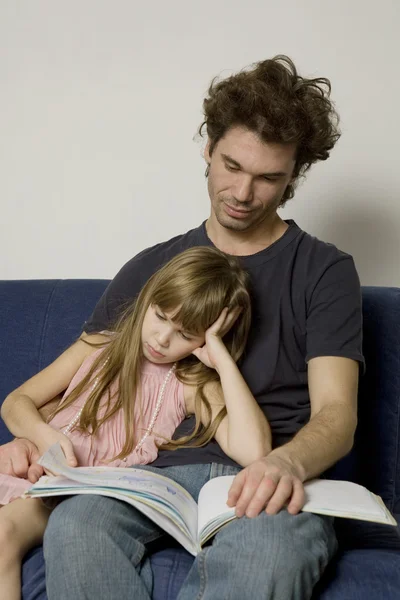 Vader en dochter zijn zittend op de Bank en lezen van een boek — Stockfoto